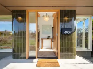 Statement front porch opening to heated tile floors.