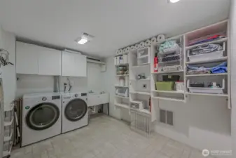 Large dedicated laundry area with storage for everyday convenience.