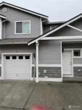 Back of condo with garage and door