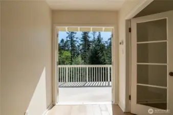 Upper hallway, looking out onto upper deck; door to primary suite to the right