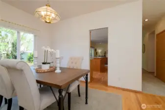 Adjacent to the kitchen, the dining room enjoys serene views out to the beautifully ladscaped back yard and patio.