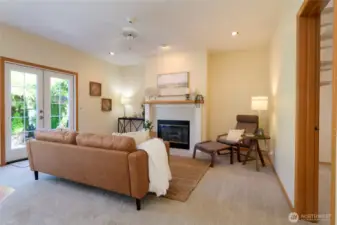 The adjacent family room features a cozy gas fireplace, creating the perfect spot for relaxing evenings or casual gatherings. French doors open to the backyard and patio, seamlessly blending indoor and outdoor living.