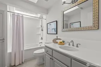 The main bathroom, so much natural light you hardly need lights. Refreshed with counters and shower surrounds painted white with epoxy paint.