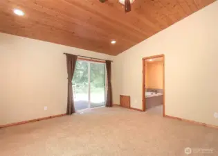 The primary suite showcases beautiful tongue-and-groove ceilings and offers direct access to the backyard deck