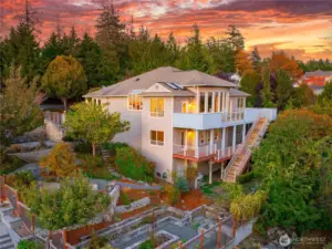 This multi-level home features expansive windows, multiple decks, and beautifully terraced landscaping for seamless indoor-outdoor living.