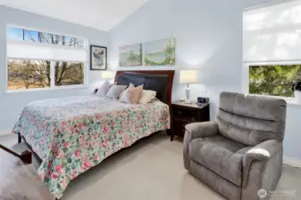 The primary bedroom features vaulted ceilings and a private ensuite bath for added comfort. As an end unit, it also enjoys an additional window that brings in even more natural light.