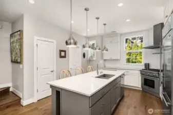 A generous walk-in pantry with custom built-in storage enhances the kitchen’s functionality, offering a clean and organized canvas for any chef.