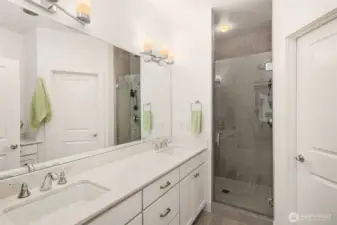 The luxurious primary bathroom offers three vanities for added convenience and a walk-in shower for a serene, private escape.