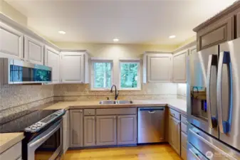 Great kitchen with ample storage, stainless appliances and a kitchen window that overlooks trees.