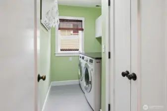 Laundry room in lower level with very functional counter top and extra storage.