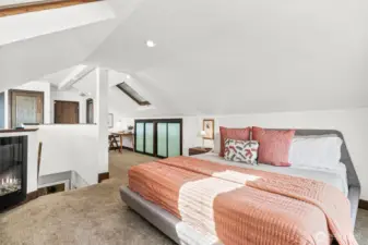 The primary bedroom features vaulted a fireplace, an en suite bath, a walk in closet, built-ins, and skylights. It's a unique and beautiful space.