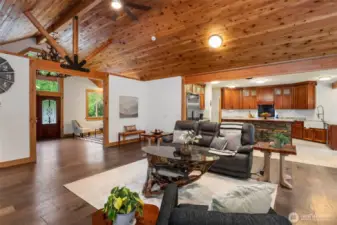 Grand room gazing into kitchen, entry and sitting room. Maple hardwood floors.