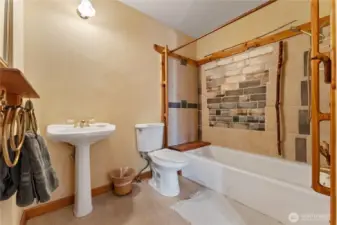 Apartment bath has a shower/tub combo with artistic wall tiles.