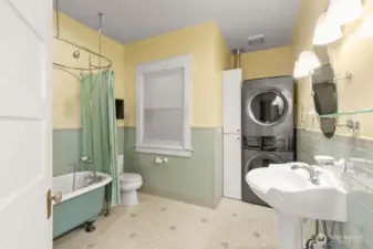 remodeled bath with new tile and original clawfoot tub, along with washer/dryer