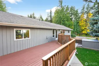 Back deck, with exterior stairs leading to fenced backyard and concrete walkway to lower unit and extra parking space. New sod put down in 2024. (Please note the extra storage shed)