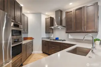 Well-designed and appointed kitchen is impeccably designed for both function and style, featuring a premium gas cooktop, double wall ovens, and a deep undermount sink. Expansive quartz countertops provide ample workspace, while custom cabinetry with pull-out shelves ensures smart, seamless storage. Whether entertaining or preparing everyday meals, this chef’s kitchen is as efficient as it is elegant.