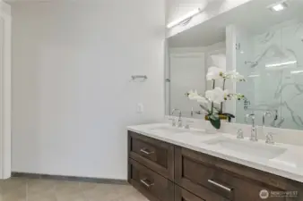Spa-inspired ensuite featuring a dual-sink vanity, quartz surfaces, and an oversized glass-enclosed shower.