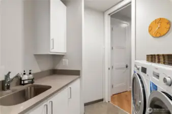 Well-appointed utility room featuring a deep sink, modern finishes, and convenient built-in storage. Walk-in pantry with built-in custom shelving.