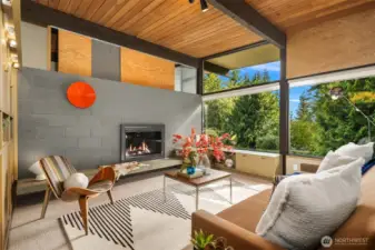 A clever sliding door above the wood-burning fireplace allows the bedroom above to open or close itself off to the main spaces below.