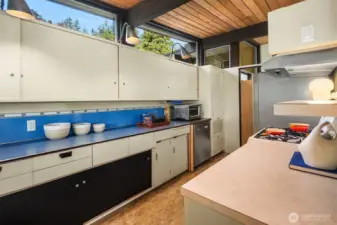 A saloon door tucks the kitchen away from the entry without making things feel closed off.  Another brilliant use of a pony wall here allows the kitchen to enjoy the beauty and light from the entry while still clearly defining itself as its own "room."