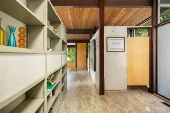 The front door is just to our right, out of frame.  Kitchen is straight ahead through the saloon door.  On our left is the other side of the living room built-in shelving.