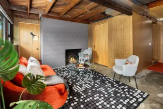 The door on the left leads to crawl space/storage, while the door to the right of the fireplace leads to more "finished" storage, with abundant racks and bins included.  Just at the base of the stairs (out of frame right) is a 3/4 bath.