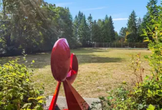 "Big Red" a sculpture by Charles W Smith (1922-2009) in 1963 looks upon the expansive community-only play grounds and tennis court.  The plaque reads:  "...a leading Northwest sculptor and an early member of Hilltop community.  He taught art and industrial design and the University of Washington for 47 years.  He loved this community and the friends he had here.