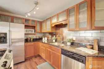 Beautiful glass-front cabinets compliment the granite countertops and stainless appliances.