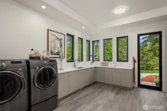 A utility room dream!  Wonderful light, access to yard and direct access to garage and tons of storage!