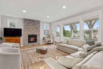 Spacious Great Room with Stone Surround Gas Fireplace and Door to a Covered Deck