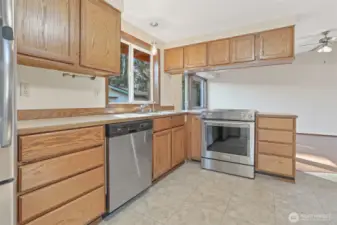 Kitchen features oak cabinets, stainless appliances including a newer kitchen aide downdraft range, an eating bar and opens to family room.