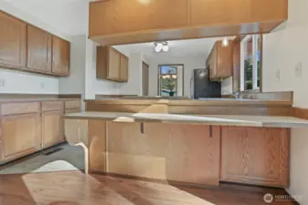 Kitchen features oak cabinets, stainless appliances including a newer kitchen aide downdraft range, an eating bar and opens to family room.
