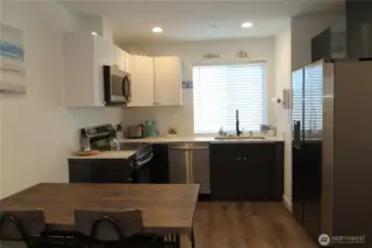 TO THE RIGHT IS THE KITCHEN WITH FULL SIZED CABINETRY, STAINLESS STEEL APPLIANCES AND GRANITE COUNTER TOPS!