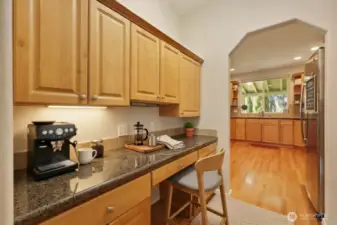 The butler’s pantry blends elegance and functionality, featuring granite countertops, built-in cabinetry, and a generous workspace perfectly positioned between the dining room and kitchen. Ideal for staging meals, storing fine dishes, or preparing drinks before dinner, it also adapts beautifully as a coffee bar or tucked-away desk area. A separate closet pantry on the opposite side provides additional storage, ensuring excellent organization and effortless flow for everyday living and entertaining.