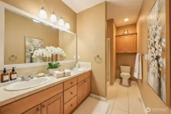 Designed as a private escape, the primary bath showcases dual vanities with ample storage, a sunlit soaking tub, and a separate shower for a complete spa-like experience. The private walk-in shower adds convenience, while warm tones and soft lighting elevate the sense of calm and comfort.