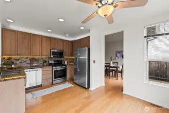 The Heart of the Home. The kitchen flows directly into a secondary living space, complete with a cozy fireplace and ceiling fan. This functional, open "great room" layout is perfect for keeping an eye on the family while preparing meals.