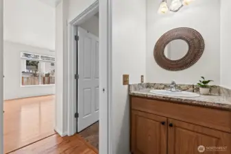 Thoughtful Details. Even the half-bath shows off high-end finishes, featuring a granite-topped vanity, rich wood cabinetry, and a unique, artisan-style mirror. It’s a stylish and convenient touch for guests on the main level.
