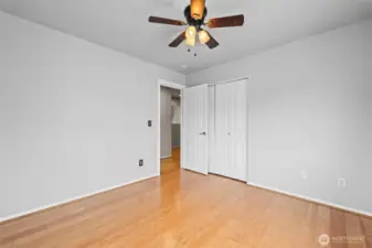 Clean & Modern. Like the rest of the home, this bedroom features updated flooring and a contemporary ceiling fan. The layout is open and airy, maintaining the home's signature feeling of spaciousness.