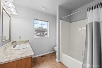 Complete Comfort. The upper-level guest bathroom is fully equipped with a tub-and-shower combo, a large vanity with granite-style countertops, and plenty of light. It’s perfectly situated to serve the secondary bedrooms.