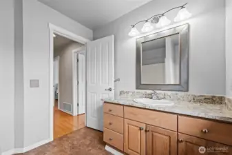Sophisticated Finishes. A closer look at the guest bath reveals the quality of the finishes, including the designer mirror and modern faucet. The warm wood cabinetry provides a beautiful contrast to the bright, clean countertop.