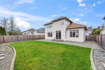 Private Outdoor Oasis. The lush green lawn is fully enclosed by a privacy fence, offering a safe and serene space for play or relaxation. Professional landscaping and stone pathways add an extra touch of charm.