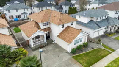 Exceptional Curb Appeal. This aerial view highlights the home’s craftsman-inspired architecture and the spacious driveway. Nestled in a quiet community, this home stands out with its beautiful design and manicured surroundings.