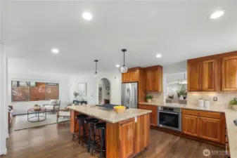 Spacious kitchen featuring a large island with seating, abundant storage, and a convenient pass-through to the dining room, ideal for effortless entertaining.