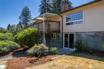 Back of home, showing sliding glass door entry into basement. There is also another entry to the basement (not visible here) to the left of the slider