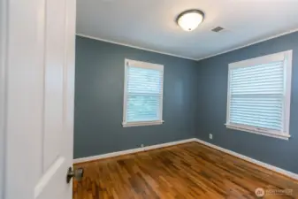 Main floor guest room - more original hardwoods and windows on 2 walls for great light.