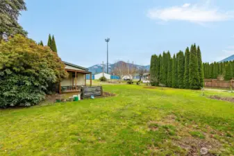 Back yard shows the raised garden bed and more area that was once used for gardening.
