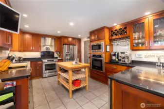 Totally remodeled and upgraded kitchen with soft-pull cherry cabinetry, quartz countertops. two ovens, wine/beverage fridge, central vac system and tile flooring.  All appliances stay.