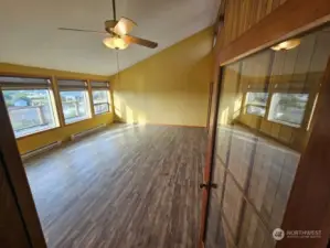 Incredibly high ceiling in the living room with a wall of windows looking out at the ocean view.