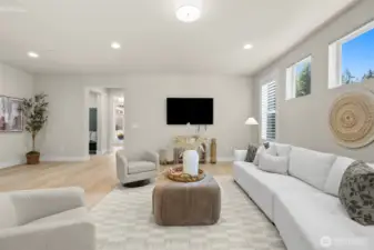 A bright and spacious living room with new floors, abundant light, and an easy flow into the kitchen