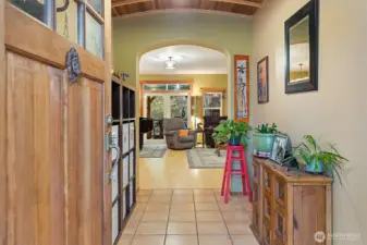 Entry features tile flooring, a stunning wood ceiling, and charming rounded archways